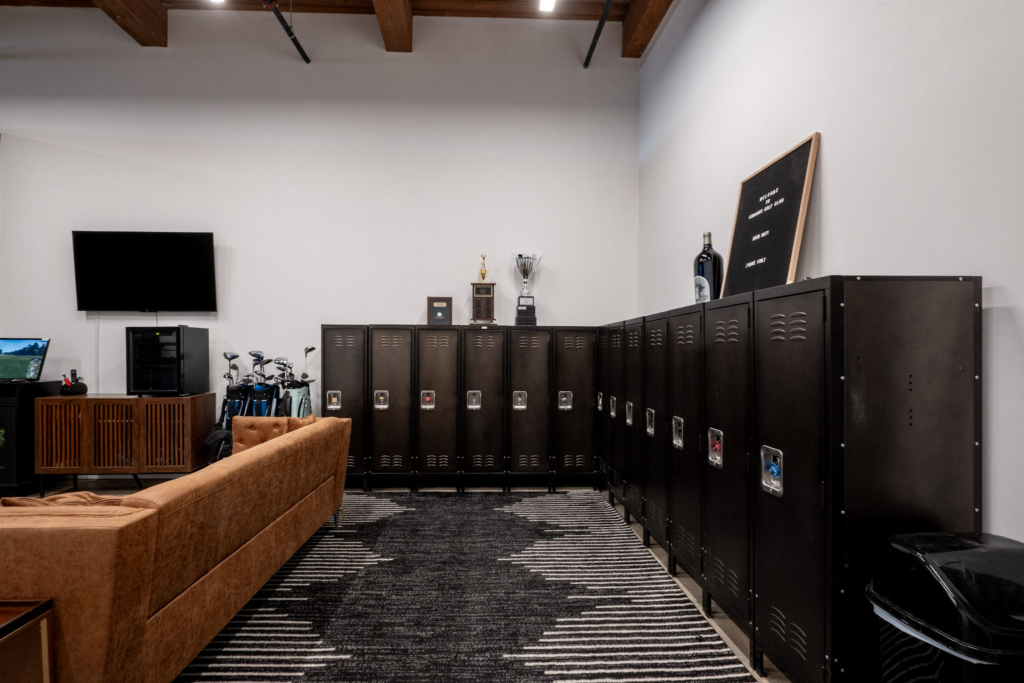 Club locker room with leather couch and trophies